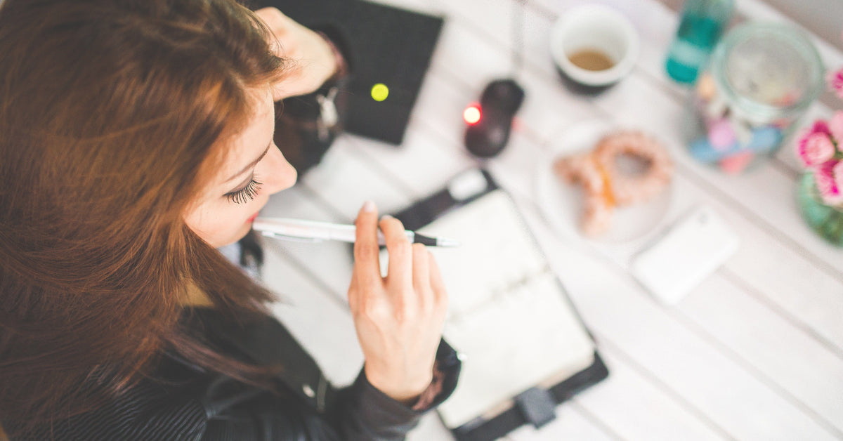 Woman beginning a focused work session at a bright home workspace